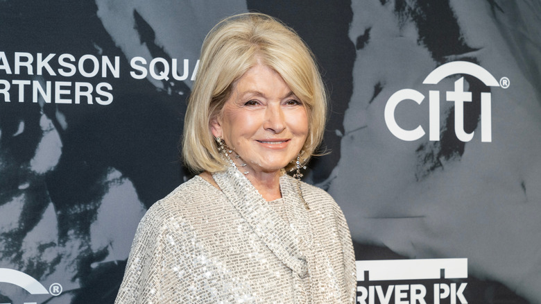 Martha Stewart smiling in front of a gray and black backdrop