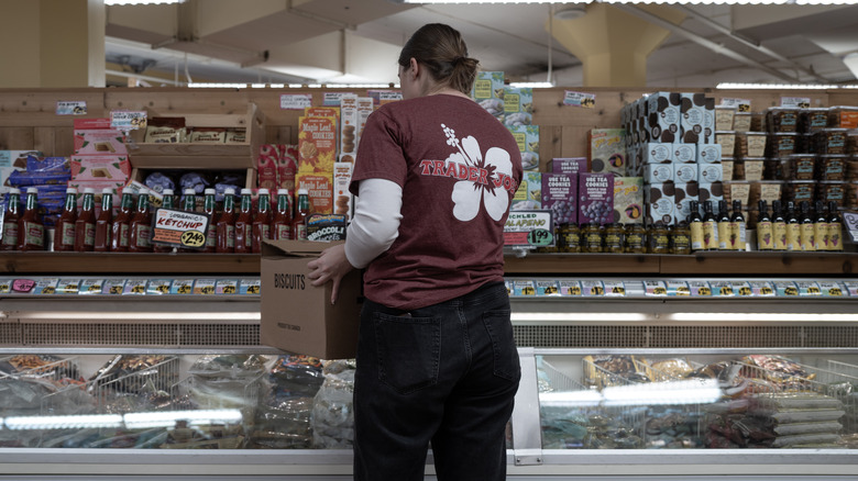 Employee stocking frozen food at Trader Joe's