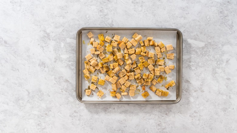 Bread cubes on baking sheet