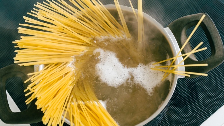 spaghetti in a stainless steel pot filled with water