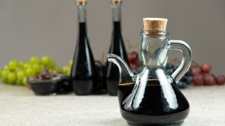 a glass jar of vinegar in the foreground and another two in the back