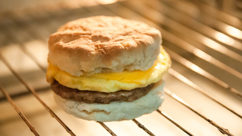 A sausage, egg, and cheese sandwich on a biscuit is on an oven rack.