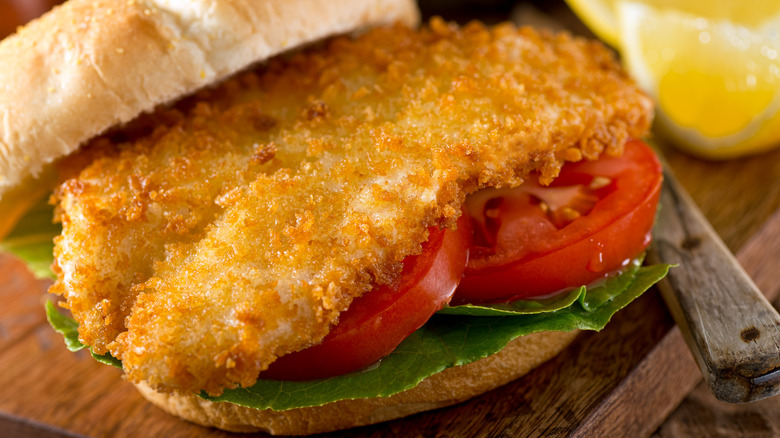 A fish burger with lettuce and tomato