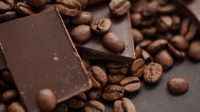 Pieces of chocolate are mixed with coffee beans.