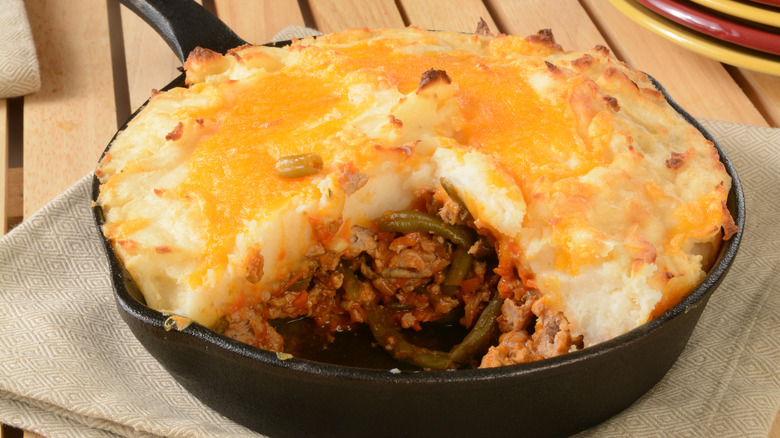 Shepherd's pie in a cast iron skillet with a slice removed