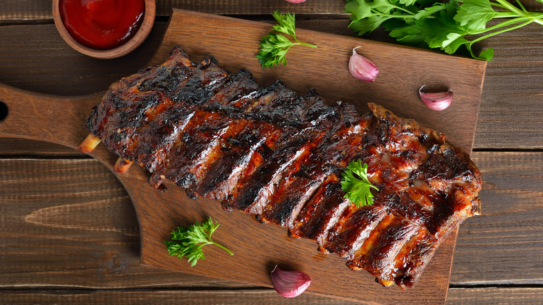 Ribs on cutting board with garlic and herbs