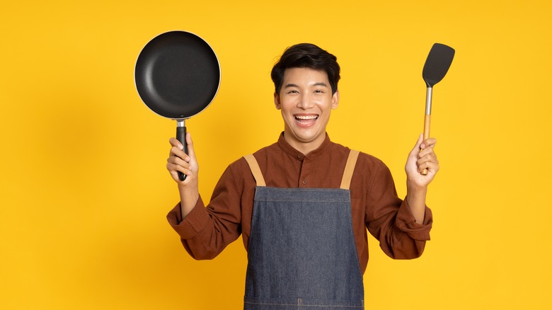 Man holding pan and spatula