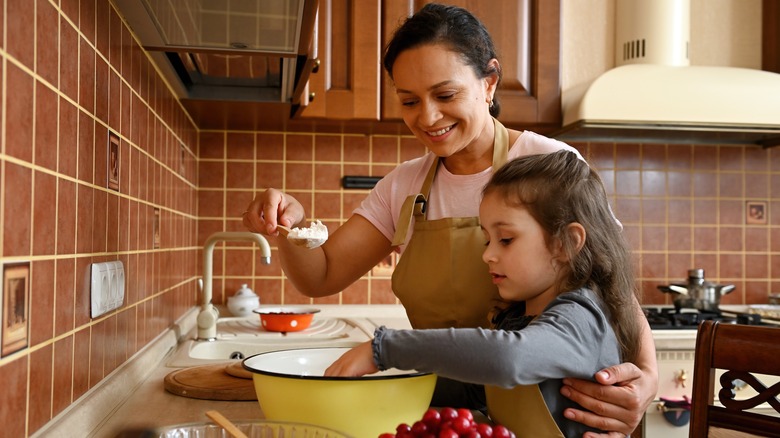 Mother and daughter make cherry pie