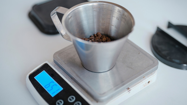 A small kitchen scale being used to measure coffee.