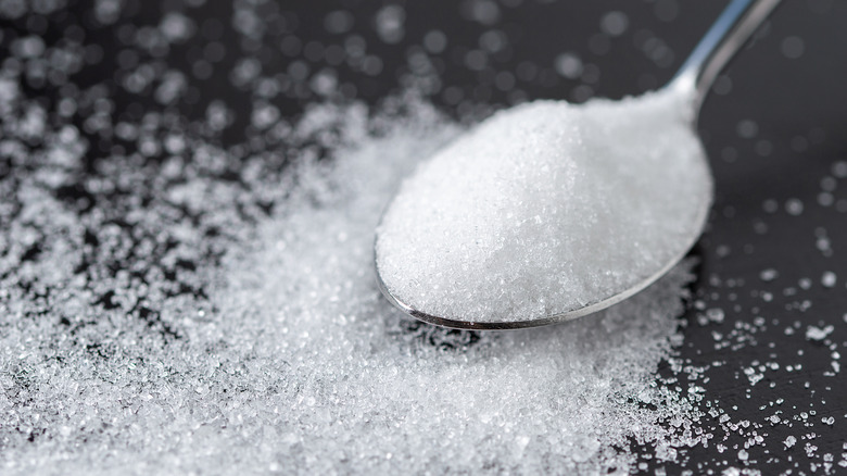 Granulated sugar on a silver spoon