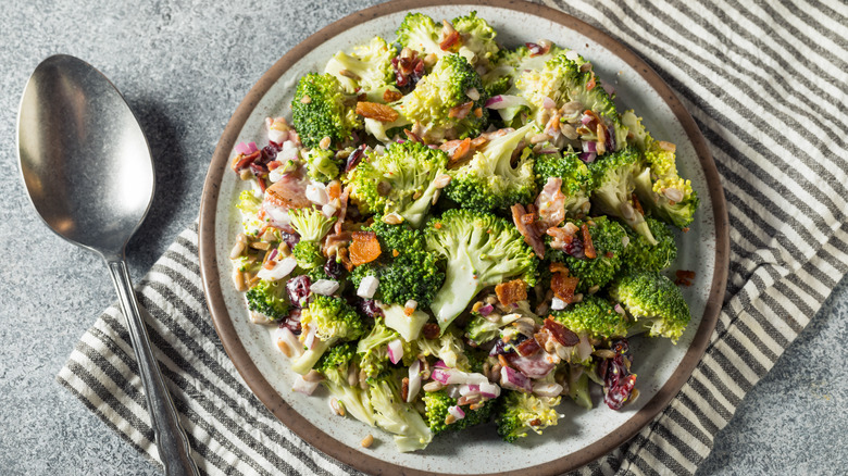 Broccoli salad on gray plate with spoon