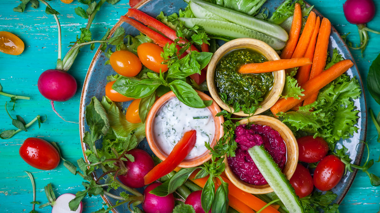 Colorful vegetable platter with three dips