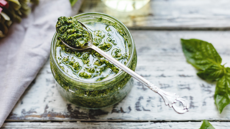 jar of pesto with spoon on table 