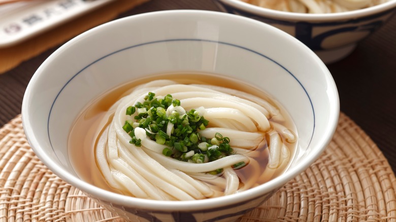 Udon noodle served in broth with green onions