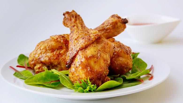 Fried chicken drumsticks over spinach