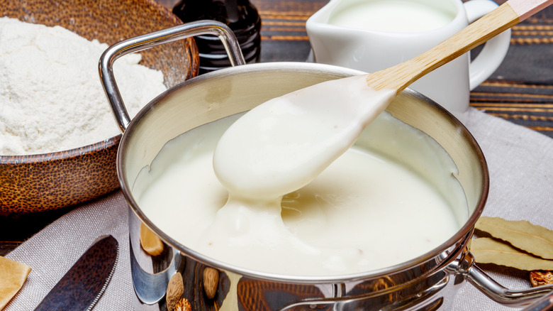Béchamel sauce in a pot with a wooden spoon