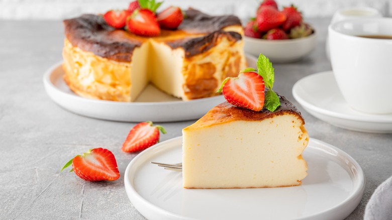 baked cheesecake slice on a plate topped with strawberries