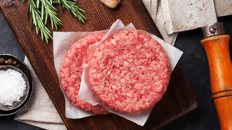 raw meat patties separated by parchment paper