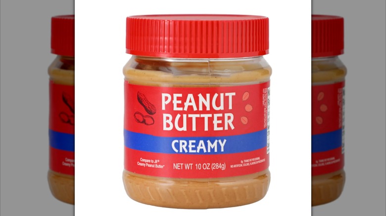 A 10 oz jar of creamy peanut butter, with a generic red and blue label