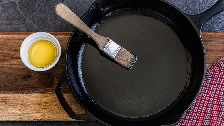 Seasoning a cast iron skillet with oil using a brush