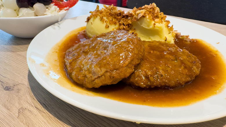 Beef patties with gravy, with mashed potatoes on the side