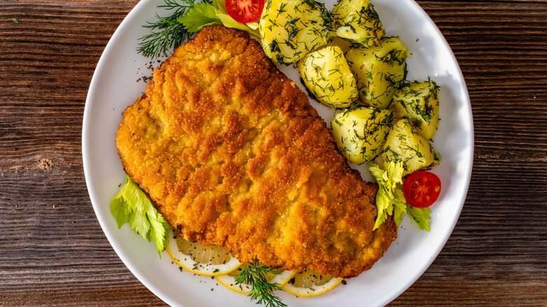 Overhead view of a breaded pork chop with potato salad