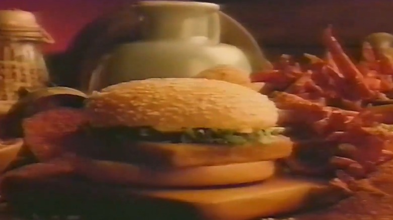 A Burger King Whaler surrounded by various condiments