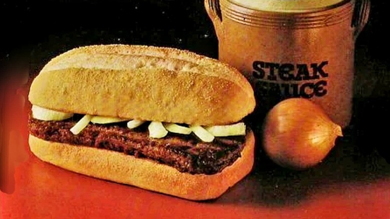 McDonald's Chopped Beefsteak Sandwich on red surface by onion and steak sauce jug