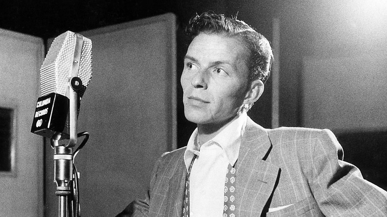 A young Frank Sinatra standing in front of a Columbia Records microphone, circa 1940s