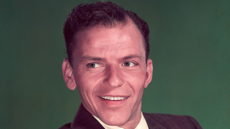 Frank Sinatra against green backdrop, smiling