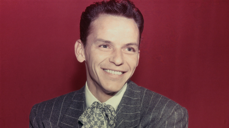 Frank Sinatra smiling with a red background