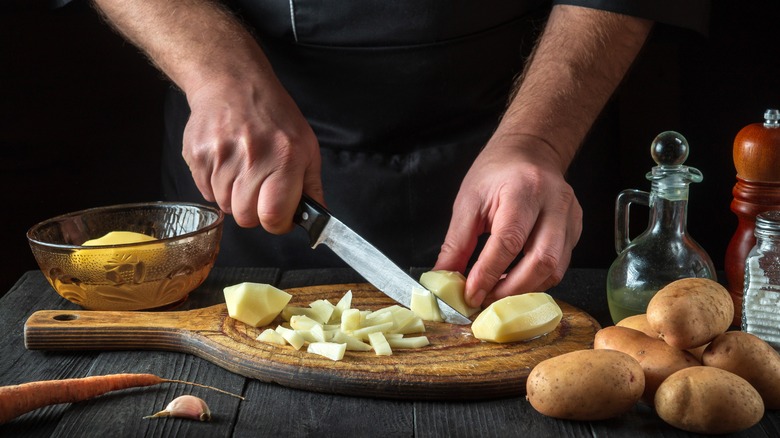 Chef cutting potatoes