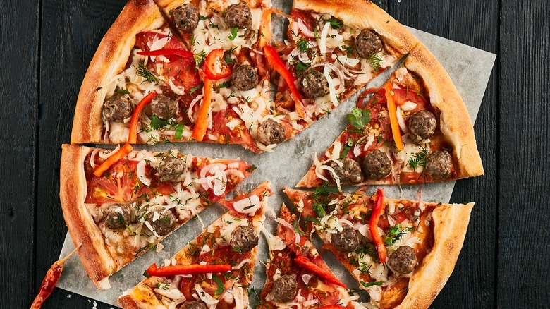 Sliced pizza on wooden board