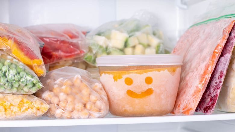 containers of frozen food on shelf in freezer