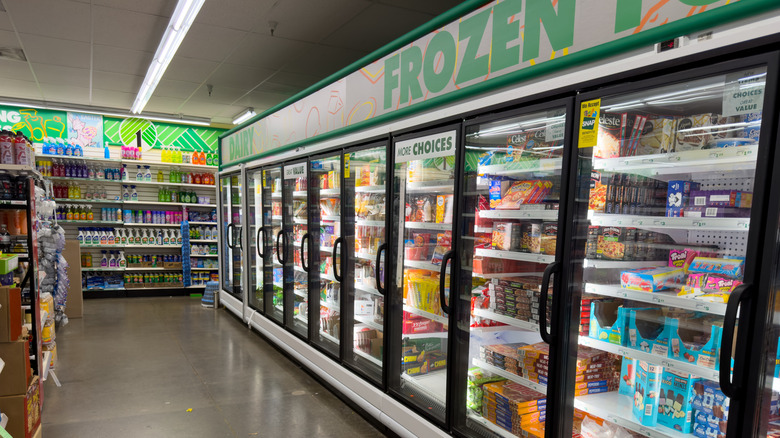 Frozen aisle of Dollar Tree with glass doors and black handles and an assortment of products inside.