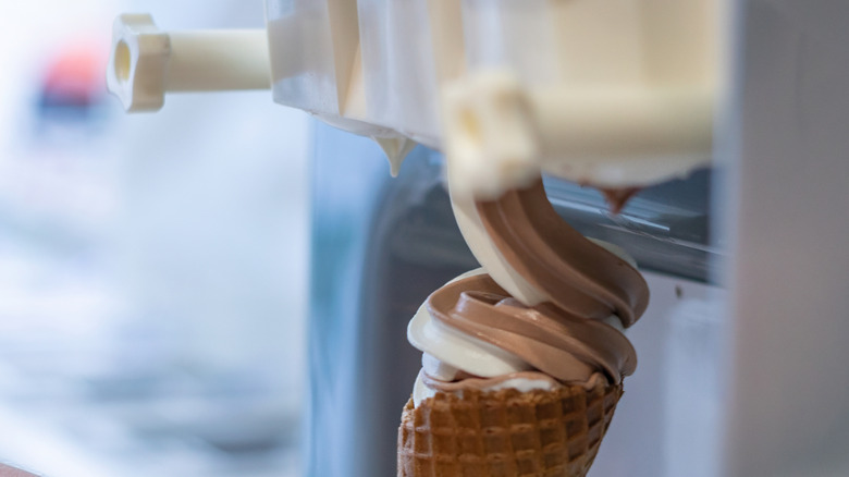 Soft chocolate and vanilla ice cream being dispensed from a soft serve machine