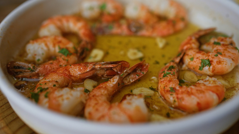 Shrimp soaking in a bowl of butter