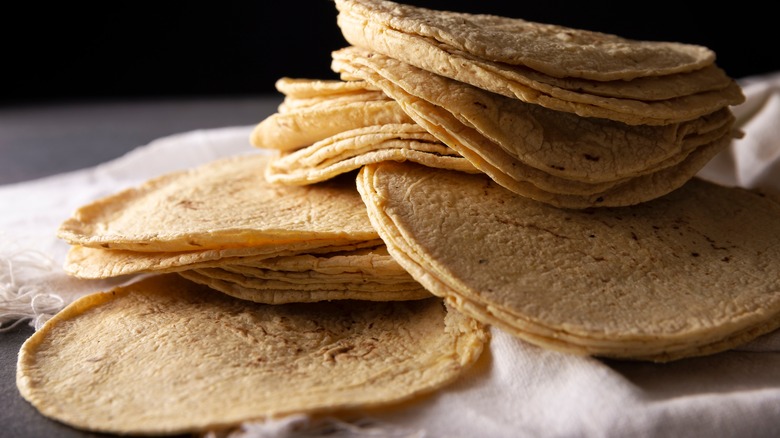 Homemade tortillas stacked on cloth