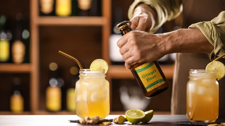 hands opening bottle of ginger beer