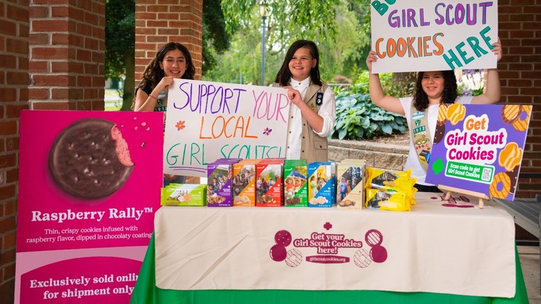 Girl Scout troop selling cookies at outdoor booth
