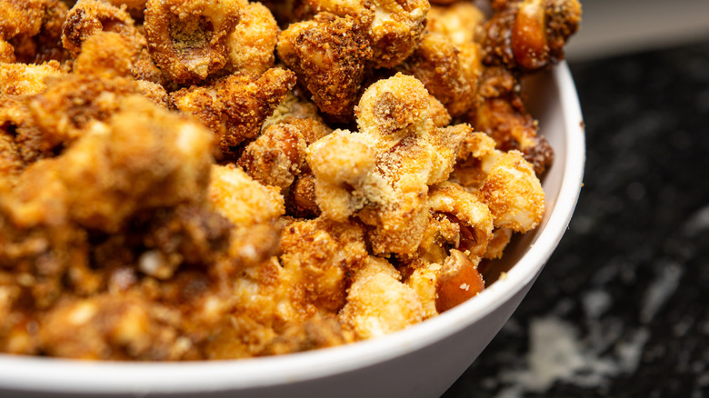 Close up of heavily seasoned popcorn in a white bowl