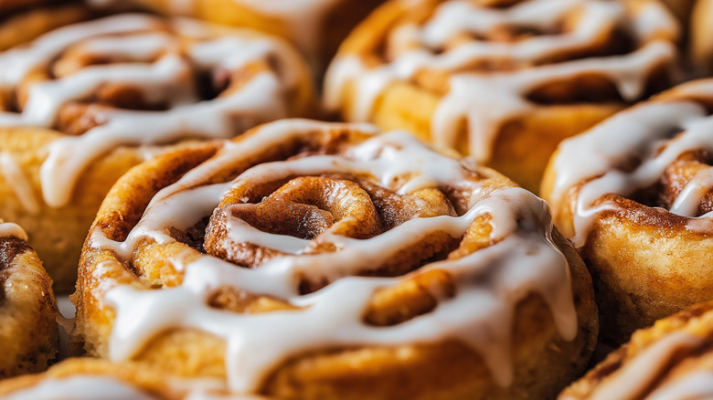 A close-up of warm cinnamon rolls with glaze on them.