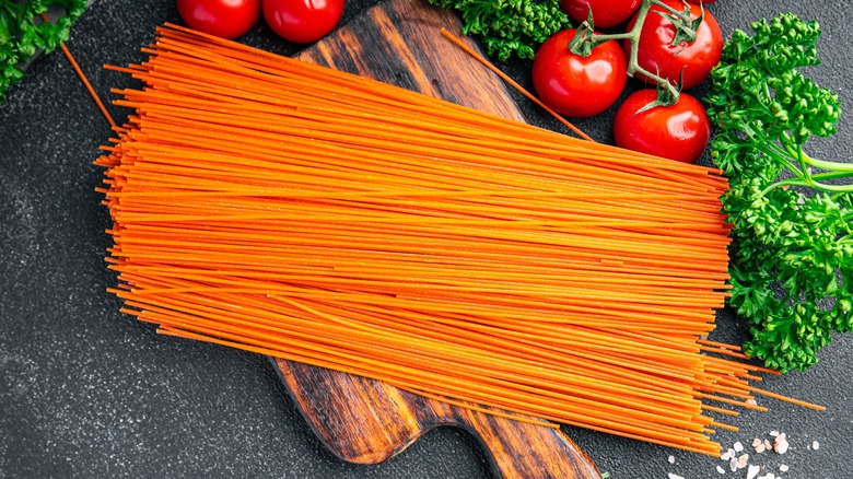 Red spaghetti noodles surrounded by tomato