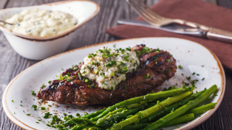 Steak with blue cheese butter on a plate with asparagus