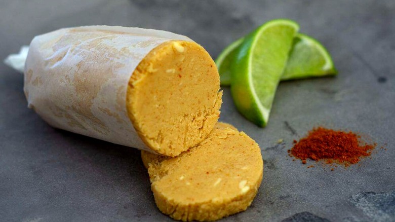 Miso lime butter wrapped up and sliced next to lime slices and seasoning