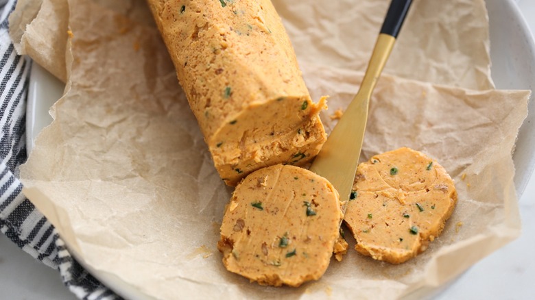 Smoked paprika and garlic butter sliced with a knife on parchment paper