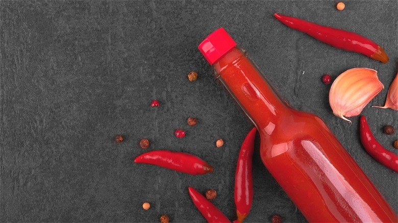 Bottle of red hot sauce on grey countertop