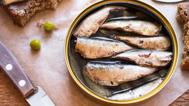 Can of sardines on a cutting board