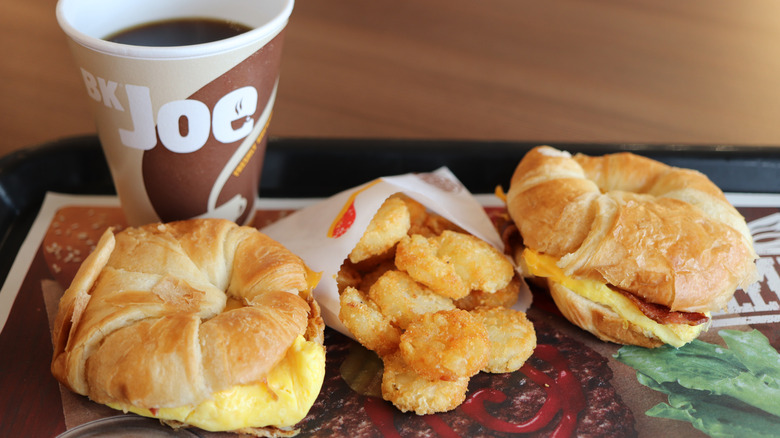 Burger King breakfast sandwiches, hashbrowns, and coffee on tray