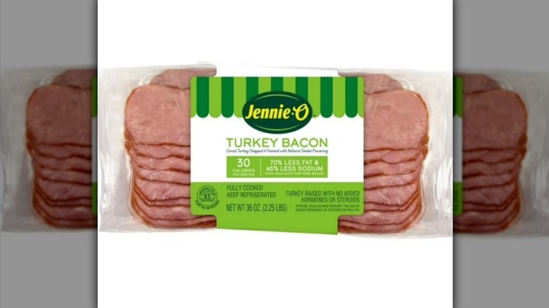 Jennie-O turkey bacon with a green and white label on white background
